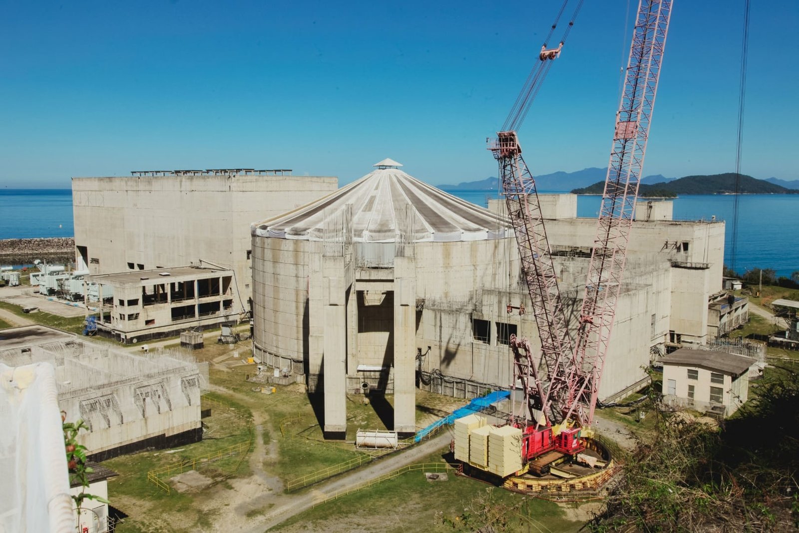 Canteiro de obras de Angra 3, com estruturas de concreto e guindastes