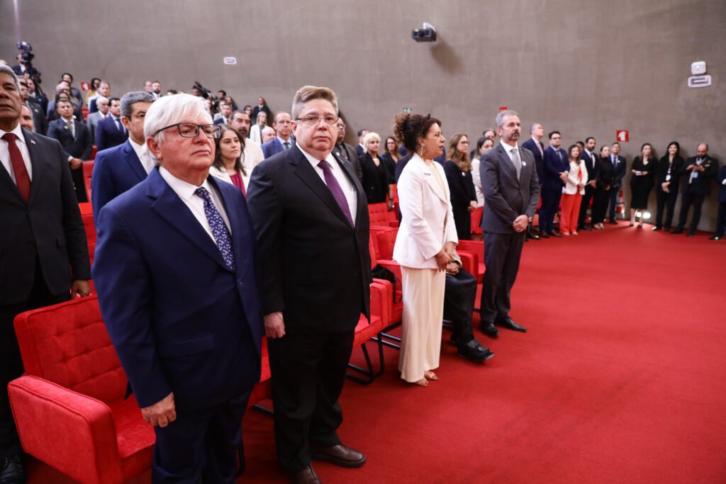 Estela Aranha, de roupa branca, e autoridades em solenidade no TSE, em fotografia de agosto de 2025.