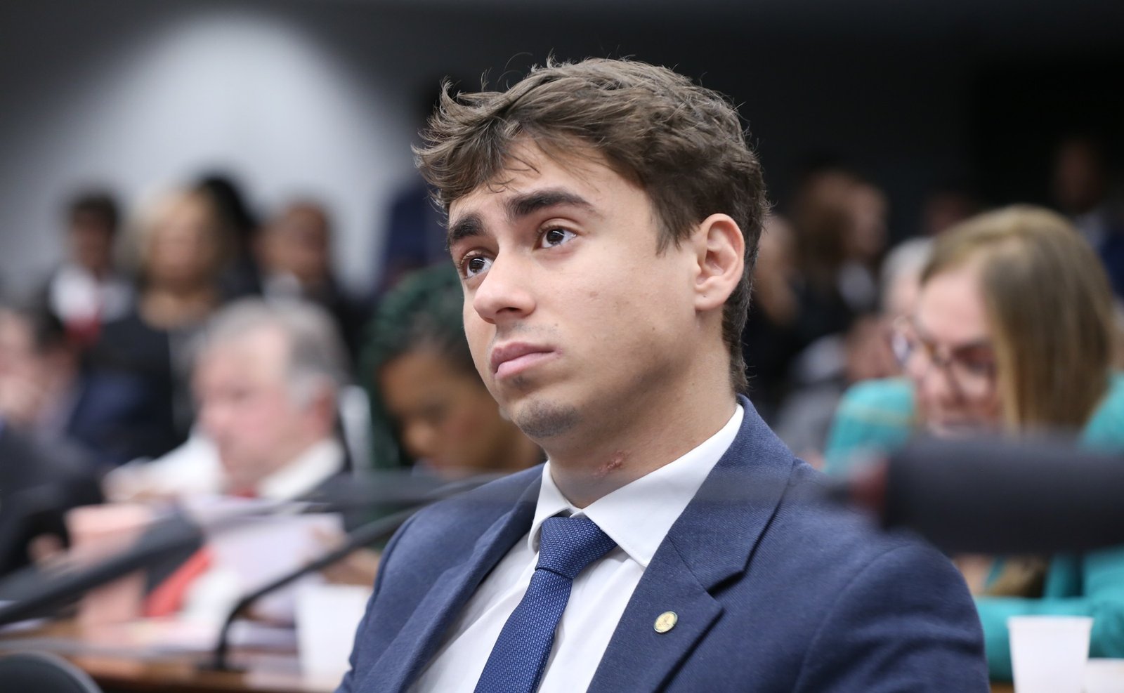 Nikolas Ferreira sentado diante de um microfone em audiência pública na Câmara.