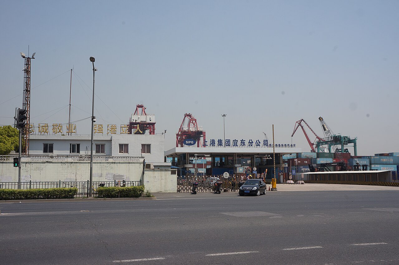 Entrada do terminal portuário de Jungong Road, em Xangai, com guindastes ao fundo.