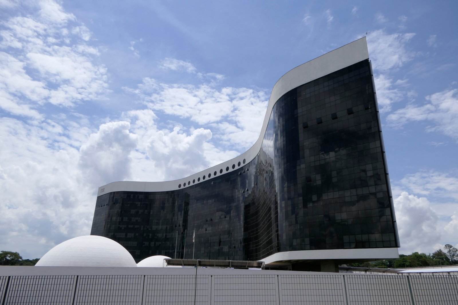 Fachada de vidro e cúpulas brancas da sede do Tribunal Superior Eleitoral, em Brasília.